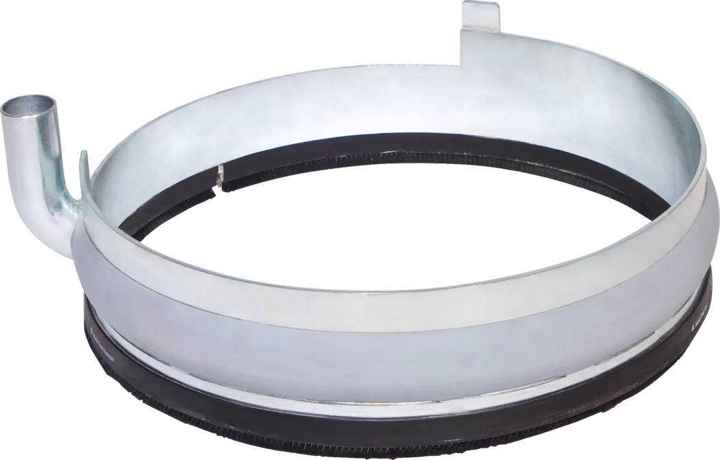 WOLFF_Dummy_72462_74177_Dust ring with extraction outlet_2025-08 En metallisk sirkulær ring med en glatt, blank overflate og en svart gummistripe på bunnkanten. Den har et utløpsrør på venstre side og en liten uthuling på høyre side, noe som tyder på at den er designet for en spesifikk mekanisk eller industriell funksjon, sannsynligvis relatert til å holde eller sikre komponenter sammen.